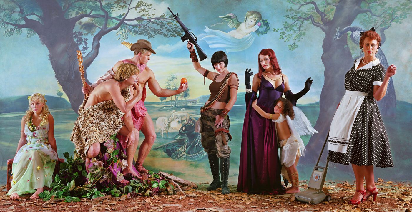 Eleanor Antin's modern allegorical photograph based on a Rubens painting. The three goddesses are modeled as a 1950s homemaker, wearing an evening gown, and dressed in camouflage holding a rifle up in the air.