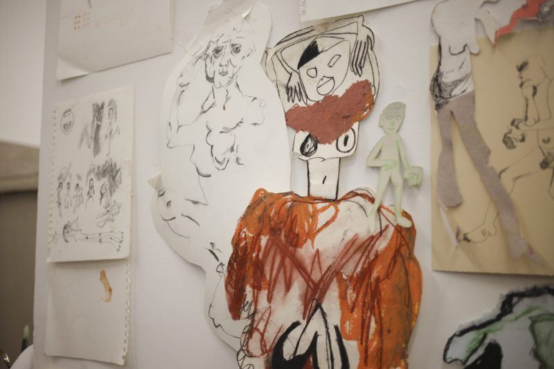 A figure is collaged together and drawn with pastels and charcoal, and stuck to the wall of Cindy Phenix's studio with tape.