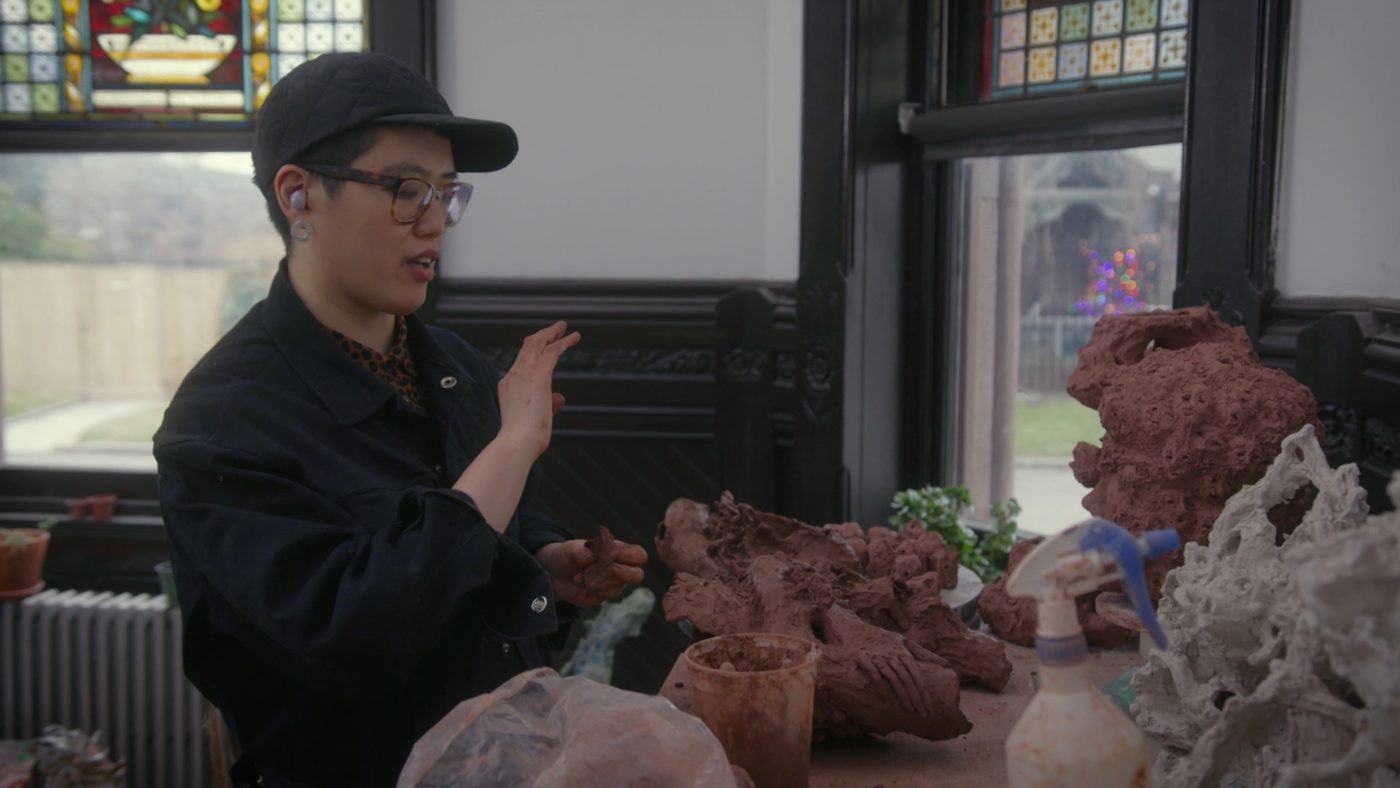 Heid Lau wearing a black cap in her studio at Green-Wood Cemetery