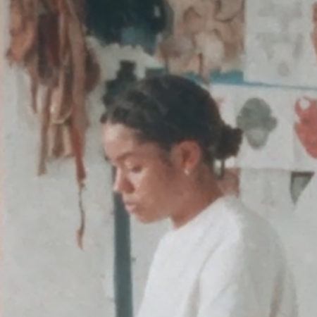Side profile of Tau lewis in her studio, wearing a white shirt.