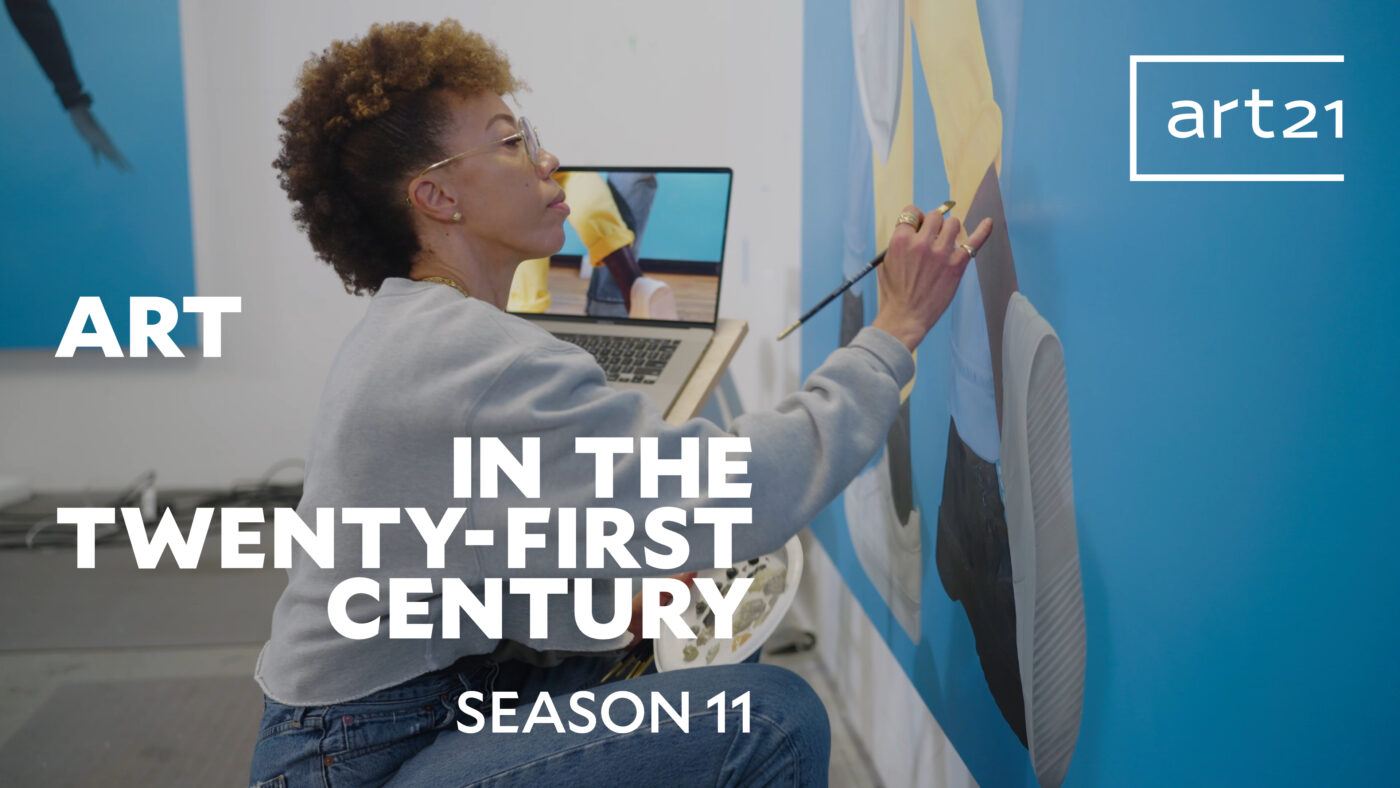 Amy Sherald holding up a paintbrush to a large-scale painting with a blue background, the title "Art in the Twenty-First Century Season 11" is laid overtop.