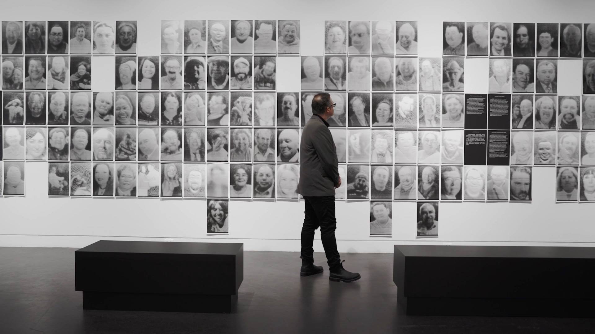 Rafael Lozano-Hemmer standing in front of the portraits created in his piece, "A Crack in the Hourglass."