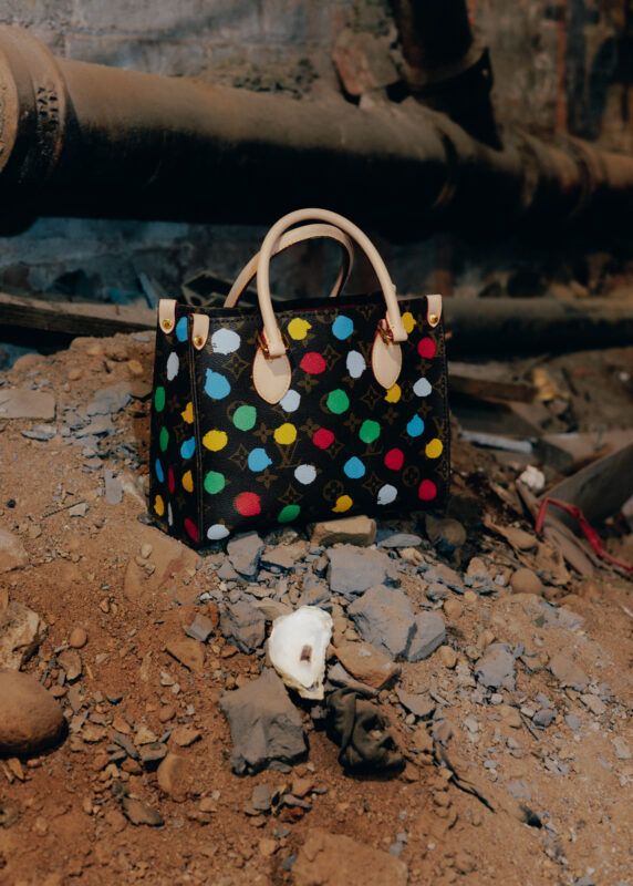 A painted 'Louis Vuitton' purse sitting on a pile of dirt and debris.