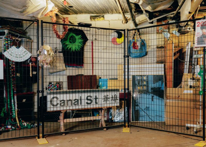 Shanzhai Lyric's studio with a "Canal Street" street sign and other items on the floor behind a metal grate fence.