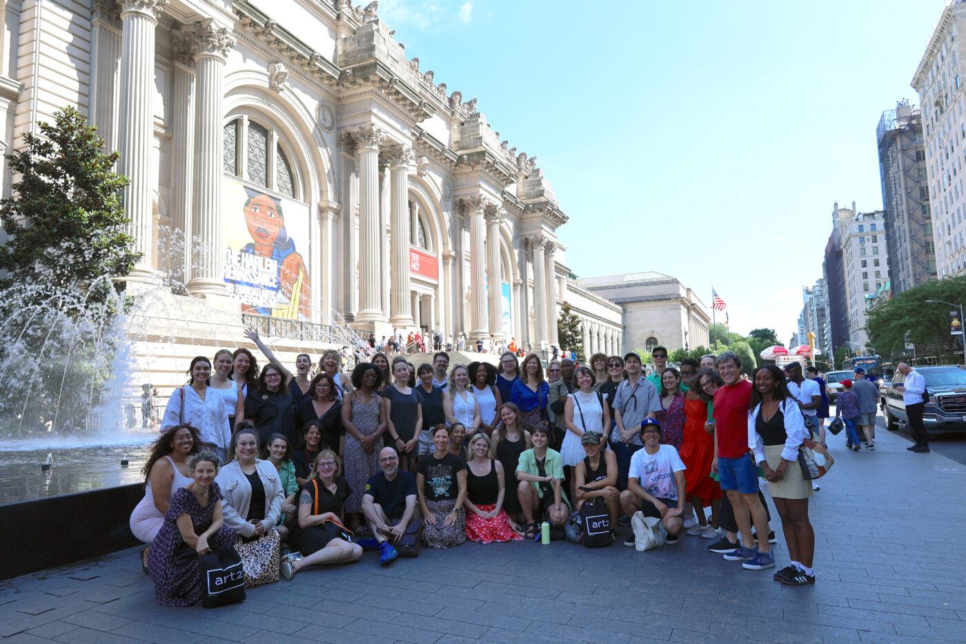 A group of people posing in front of The Metropolitan Musuem of Art.