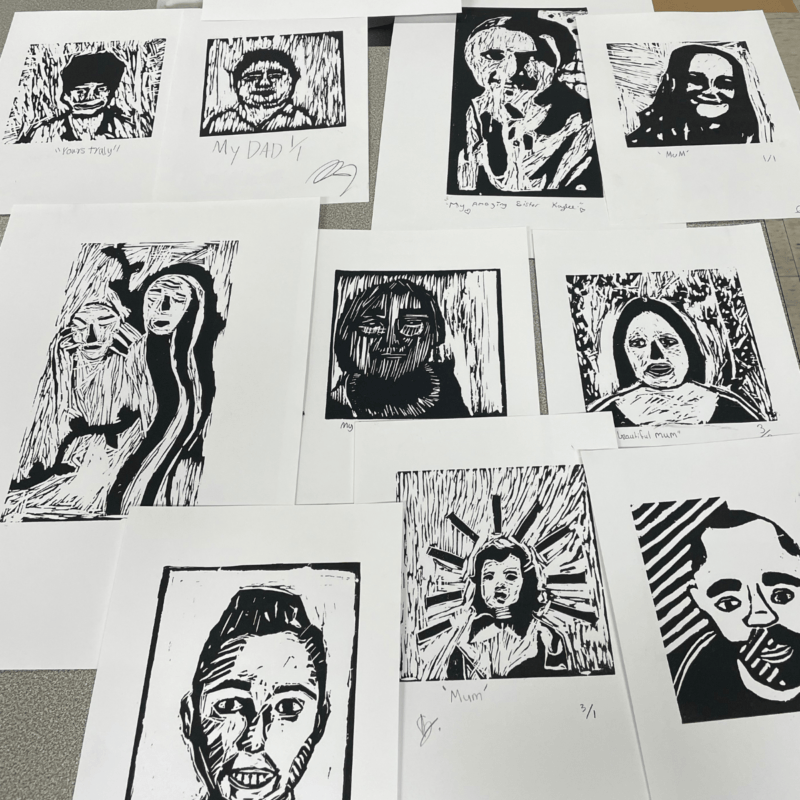 A collection of black and white abstract portraits displayed on a table.