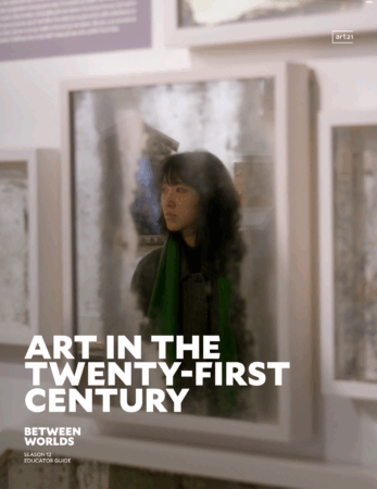 A woman with dark hair and a green scarf is reflected in a glass surface, surrounded by framed artworks in a gallery. Text reads: "Art in the Twenty-First Century / Between Worlds / Season 12 / Educator Guide"