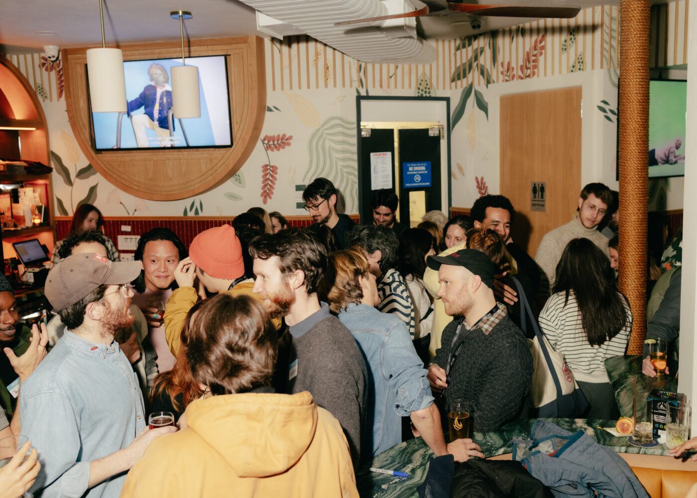A crowded bar with people socializing and drinking.