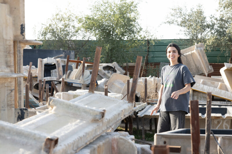 Alia Farid standing outside beside plastic molds