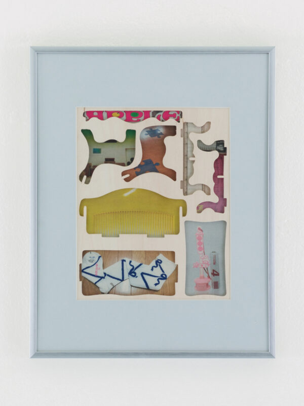 Framed artwork featuring cut-out shapes arranged in compartments, with various colors and patterns, including yellow, pink, blue, and beige tones.